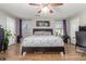 Bright bedroom with king-size bed, ceiling fan, and wood flooring at 2715 S Sailors Way, Gilbert, AZ 85295