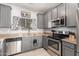 Modern kitchen with gray cabinets, granite countertops, and stainless steel appliances at 2715 S Sailors Way, Gilbert, AZ 85295