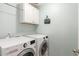 Laundry room with washer, dryer, and overhead cabinets at 2715 S Sailors Way, Gilbert, AZ 85295