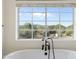 Bathroom with freestanding tub and window with mountain views at 27921 N 153Rd St, Scottsdale, AZ 85262