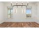 Bright dining room with hardwood floors, large windows, and modern chandelier at 27921 N 153Rd St, Scottsdale, AZ 85262