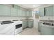 Modern laundry room with light green cabinets and granite counters at 27921 N 153Rd St, Scottsdale, AZ 85262