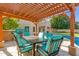 Relaxing patio under a wooden pergola with seating for six at 3210 E Brookwood Ct, Phoenix, AZ 85048