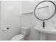 Clean bathroom with pedestal sink and round mirror at 356 W Ivanhoe St, Gilbert, AZ 85233