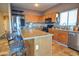 Kitchen with an island, stainless steel appliances, and wood cabinets at 35706 W Costa Blanca Dr, Maricopa, AZ 85138