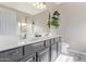 Bathroom featuring double sinks, a large mirror, and decorative plants at 3711 E Sandy Way, Gilbert, AZ 85297