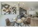 Glass dining table with four chairs, stylish chandelier, and view into living room at 4910 W Townley Ave # 4910, Glendale, AZ 85302