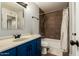 Bathroom with blue vanity, shower/tub combo, and tile surround at 5005 S Mill Ave, Tempe, AZ 85282