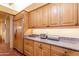 Kitchen with wood cabinetry, granite countertops, and a built-in refrigerator at 5113 W Arrowhead Lakes Dr, Glendale, AZ 85308