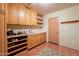 Laundry room with wood cabinets, shelving, and a utility sink at 5113 W Arrowhead Lakes Dr, Glendale, AZ 85308