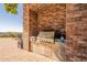 Built-in outdoor kitchen with grill and brick facade at 5113 W Arrowhead Lakes Dr, Glendale, AZ 85308