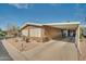 Tan manufactured home with carport and neatly landscaped yard at 5402 E Mckellips Rd # 276, Mesa, AZ 85215