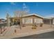 Tan single-wide manufactured home with carport and desert landscaping at 5402 E Mckellips Rd # 276, Mesa, AZ 85215