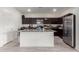 Modern kitchen that features an island, stainless steel appliances, and dark cabinetry at 670 E Wiley Way, Casa Grande, AZ 85122