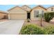 Tan house with gray shutters, two-car garage, and landscaped front yard at 7225 W Jones Ave, Phoenix, AZ 85043