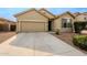 Tan house with gray shutters, two-car garage, and landscaped front yard at 7225 W Jones Ave, Phoenix, AZ 85043