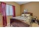 Bedroom with a double bed, nightstand, and red curtains at 7325 W Pleasant Oak Way, Florence, AZ 85132