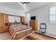 Bedroom with wooden furniture, patterned bedding, and large window at 7332 S Briarwood Ln, Gilbert, AZ 85298