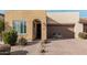 Tan house with a two-car garage and landscaped front yard with a bike at 880 E Verde Blvd, Queen Creek, AZ 85140