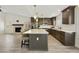 Open-concept kitchen with grey cabinets, stainless steel appliances, island seating, and fireplace in the living area at 9230 N 104Th Pl, Scottsdale, AZ 85258
