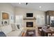 Living room with fireplace, comfortable seating, and adjacent laundry room at 9230 N 104Th Pl, Scottsdale, AZ 85258