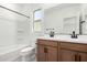 Bright bathroom with wood cabinets, dual sinks, a shower and tub combo, and a window at 9350 E Sequence Ave, Mesa, AZ 85212