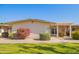 Tan single story home with landscaped yard and covered patio at 10429 W Highwood Ln, Sun City, AZ 85373