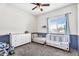 Bright Bedroom with a white crib, stylish dresser, chaise lounge, and decoratively painted lower wall at 1923 E Drake Dr, Tempe, AZ 85283
