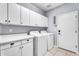 Practical laundry room with modern appliances, countertop space, and ample storage cabinets at 1923 E Drake Dr, Tempe, AZ 85283