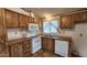 L-shaped kitchen with white appliances and wood cabinets at 2233 E Behrend Dr # 115, Phoenix, AZ 85024