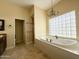 Luxurious bathroom featuring a large soaking tub and a chandelier at 2332 E Nora St, Mesa, AZ 85213