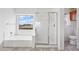 White bathroom features a tub under a window and a glass enclosed shower at 2338 N 112Th Ln, Avondale, AZ 85392