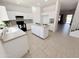 A spacious kitchen offers white cabinets, an island, black appliances, and neutral countertops at 2338 N 112Th Ln, Avondale, AZ 85392