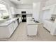 Bright kitchen features white cabinets, an island, black appliances, and neutral countertops at 2338 N 112Th Ln, Avondale, AZ 85392