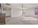 Spacious main bedroom featuring neutral carpeting, a ceiling fan, and access to an en-suite bathroom at 2338 N 112Th Ln, Avondale, AZ 85392