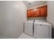 Laundry room with washer, dryer, and upper cabinets at 24201 W Lasso Ln, Buckeye, AZ 85326