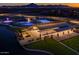 Aerial view of community pool, clubhouse, and surrounding landscape at dusk at 26128 S 228Th Pl, Queen Creek, AZ 85142