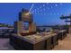 Outdoor seating area with fire pit and string lights at dusk at 26128 S 228Th Pl, Queen Creek, AZ 85142