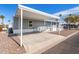 Gray mobile home with covered carport and ramp access at 2650 W Union Hills Dr # 231, Phoenix, AZ 85027