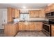L-shaped kitchen with light wood cabinets and stainless steel appliances at 2650 W Union Hills Dr # 231, Phoenix, AZ 85027