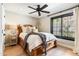 Cozy bedroom with an ornate wooden bed frame, hardwood floors, and a large window at 3048 N 45Th St, Phoenix, AZ 85018