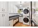 Functional laundry room with built-in cabinets, dark countertop, wood floors, and a stacked washer/dryer at 3048 N 45Th St, Phoenix, AZ 85018