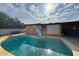 Backyard pool with slide and tile steps leading into the clear, blue water with bright sunshine and reflections at 3726 W Coolidge St, Phoenix, AZ 85019