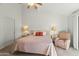 Bedroom featuring a cozy bed, side tables with lamps, a ceiling fan and neutral walls at 4301 E Montecito Ave, Phoenix, AZ 85018