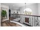 Open upper hallway featuring a curved wrought iron railing and wood flooring at 4543 S Roy Rogers Way, Gilbert, AZ 85297