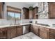 Modern kitchen features dark wood cabinets, stainless steel appliances, and quartz countertops at 4543 S Roy Rogers Way, Gilbert, AZ 85297