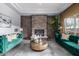 Living area with a stone fireplace and plush emerald green sofas at 4543 S Roy Rogers Way, Gilbert, AZ 85297