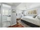 Airy main bedroom featuring natural light, a ceiling fan, light blue walls, and an attached bathroom at 4631 E Catalina Dr, Phoenix, AZ 85018