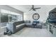 Spacious living room with gray sectional sofa, large clock, and flat-screen TV at 4740 E Cambridge Ave, Phoenix, AZ 85008