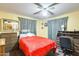 Cozy bedroom with yellow walls, a ceiling fan, and furnished with a wooden dresser and a desk at 5501 E Dallas St, Mesa, AZ 85205